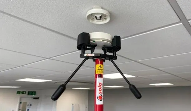 Haste de teste aplicando estímulo em detector de fumaça instalado no teto