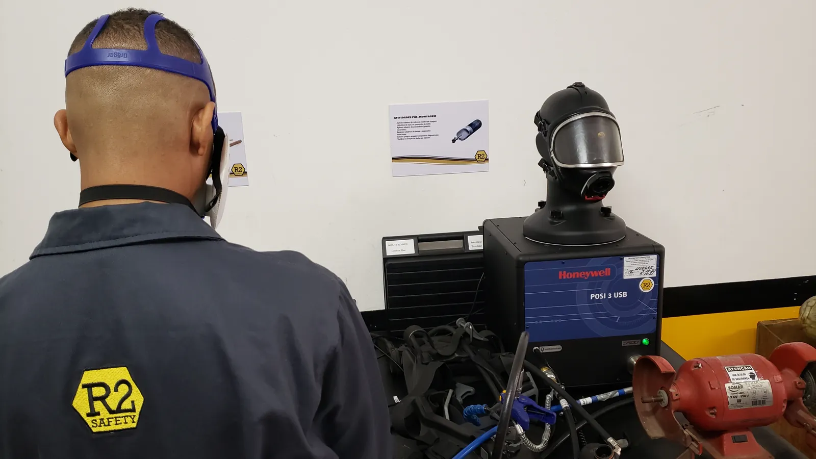 Técnico com uniforme da R2 Safety diante da cabeça de teste de máscaras